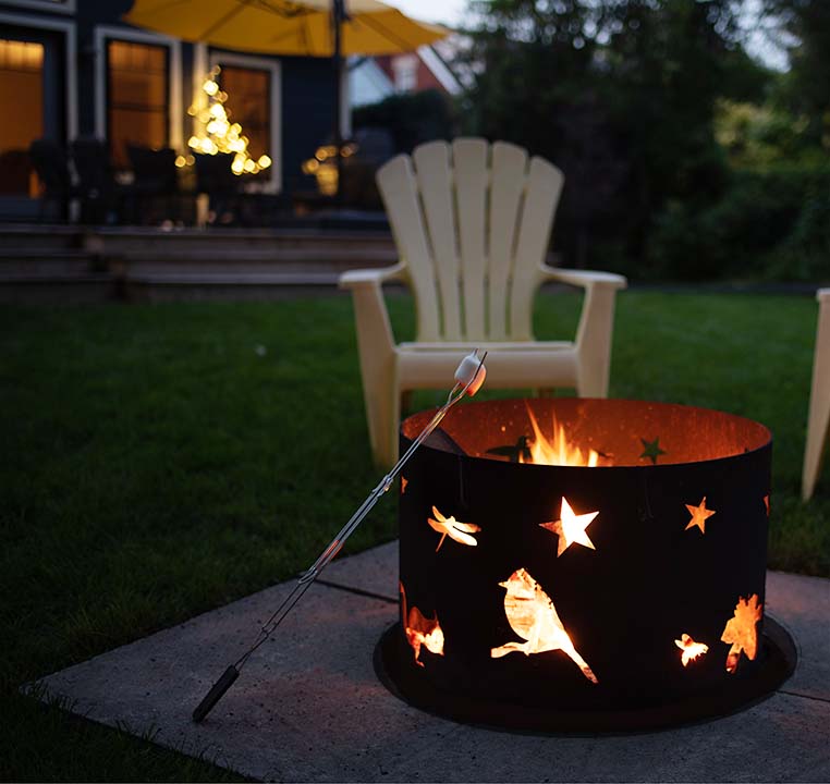 Photo of campfire stone in a backyard setting with a metal surround, marshmallow on a stick. Easy set up! Just four stones.