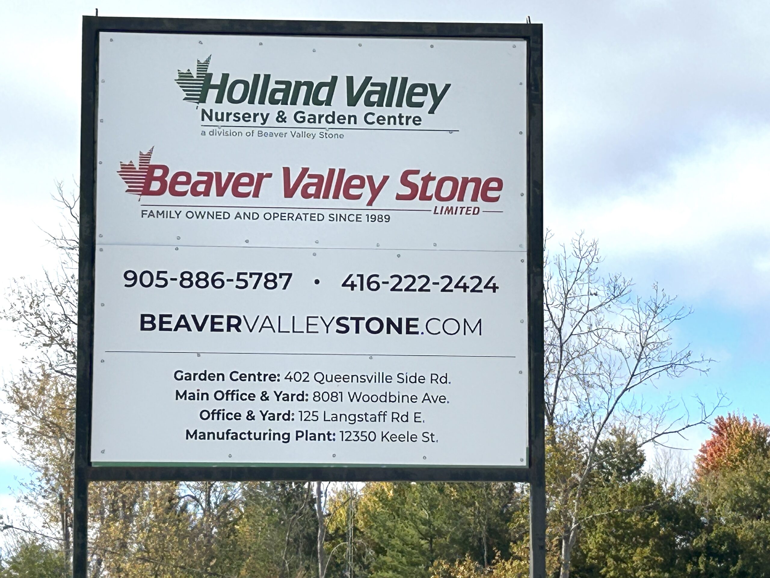 A sign with Beaver Valley Stone Family owned and operated since 1989. 905.886.5787 and 416.222.2424, BeaverValleyStone.com, Garden Centre: 402 Queensville Side Road. Main Office and Yard: 8081 Woodbine Avenue; Office and Yard: 125 Langstaff Road East; Manufacturing Plant: 12350 Keele Street.