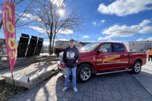 An image of a man standing in front of a Hamilton Builder Supply Pick up truck